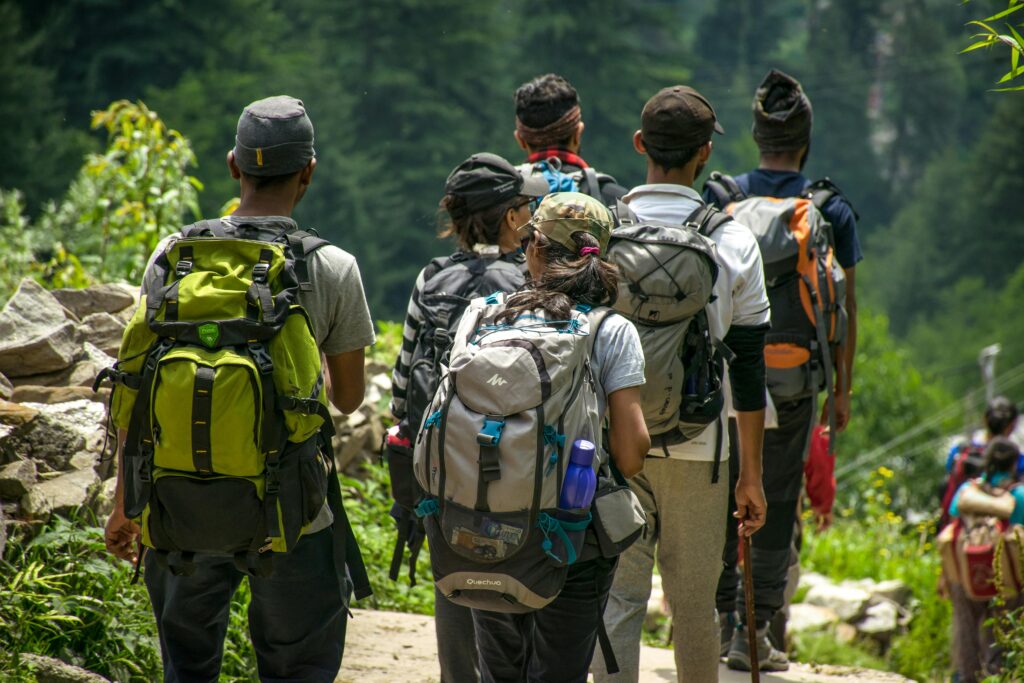pexels-photo-1076081-1076081 An adventurous group hike in a lush forest setting with vibrant green surroundings.